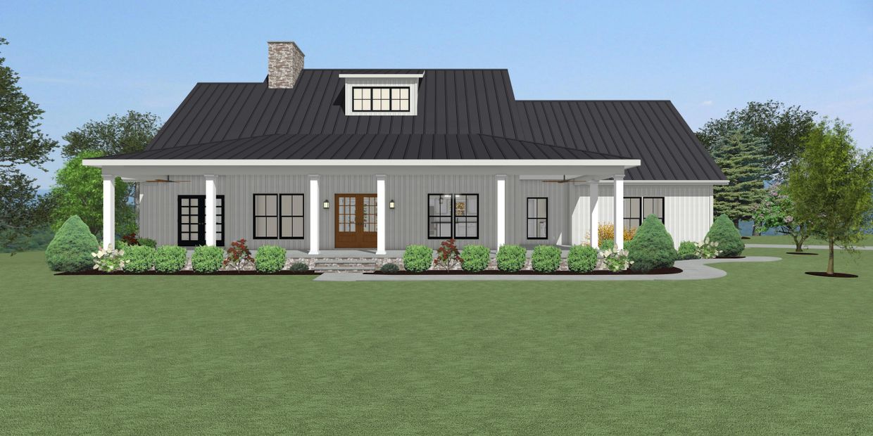 Modern farmhouse with black metal roof and white exterior surrounded by greenery.