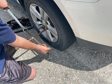 Changing a flat tire along the highway