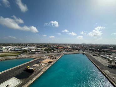 Aerial view of a harbor with clear blue water and surrounding industrial area.