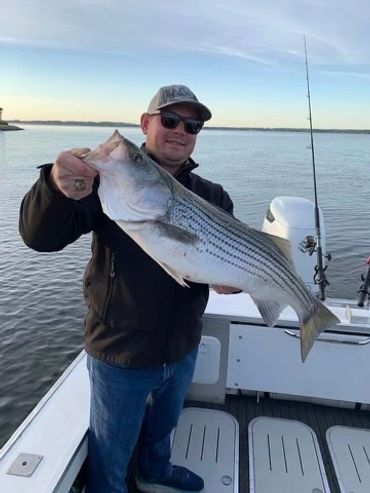 A picture of a man holding a fish while its mouth is open