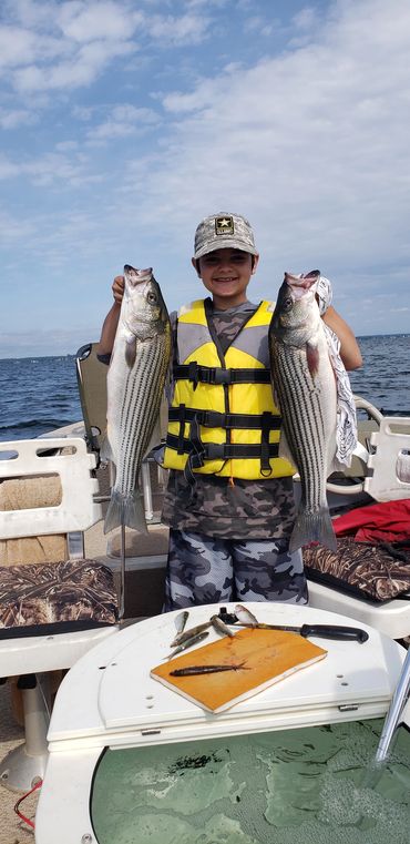 A picture of a boy holding to fishes