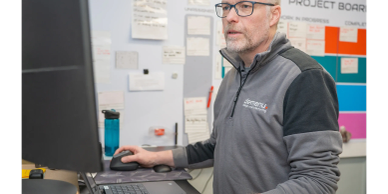 Man working on a computer in an office setting.