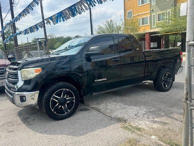 Black Toyota Tundra parked outdoors near buildings.