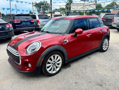 Red Mini Cooper parked in a lot.