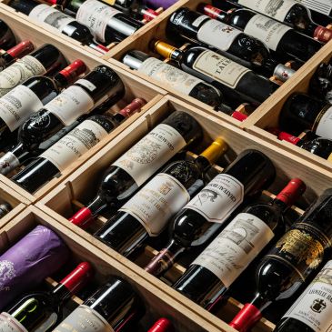 Rows of assorted wine bottles stored in wooden racks.