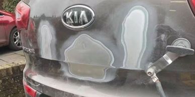 Car with sanded patches on rear and UK plate.