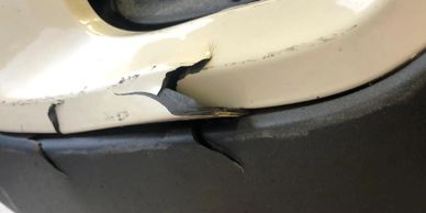 Cracked and peeling damage on a vehicle bumper.