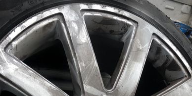 Close-up of a scratched alloy wheel rim.