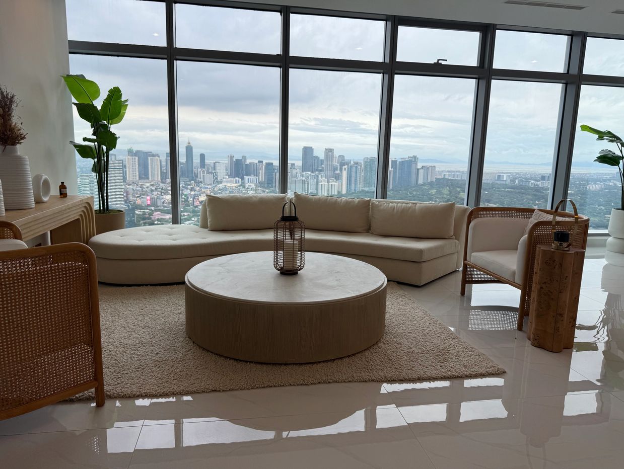 Modern living room with large windows overlooking a city skyline.