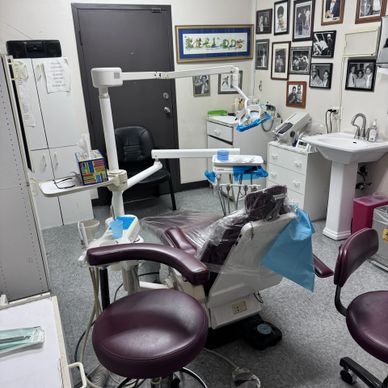 A dental clinic room with equipment and chairs arranged neatly.