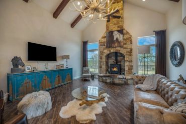 Cozy living room with stone fireplace and rustic decor.