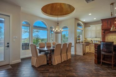 Elegant dining area with large arched windows and wooden flooring.