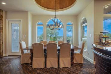 Elegant dining room with large windows and chandelier.