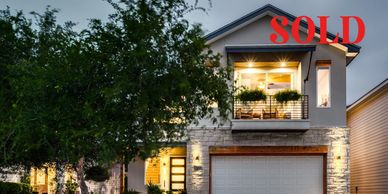 Modern two-story house with garage marked as sold.