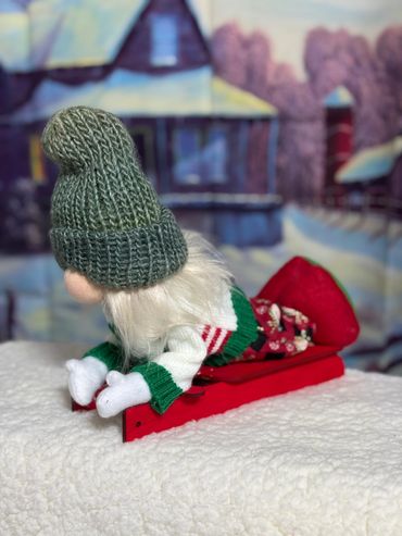 2024 Sled Girl with white mittens and blue green hat. 9 inches tall.