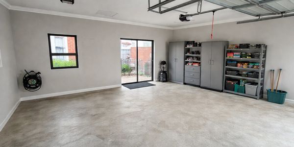 Clean and organized garage with storage cabinets and shelves.