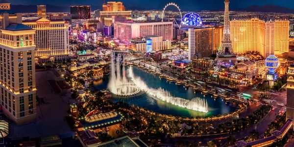 Vibrant Las Vegas Strip at night with fountains and iconic landmarks.