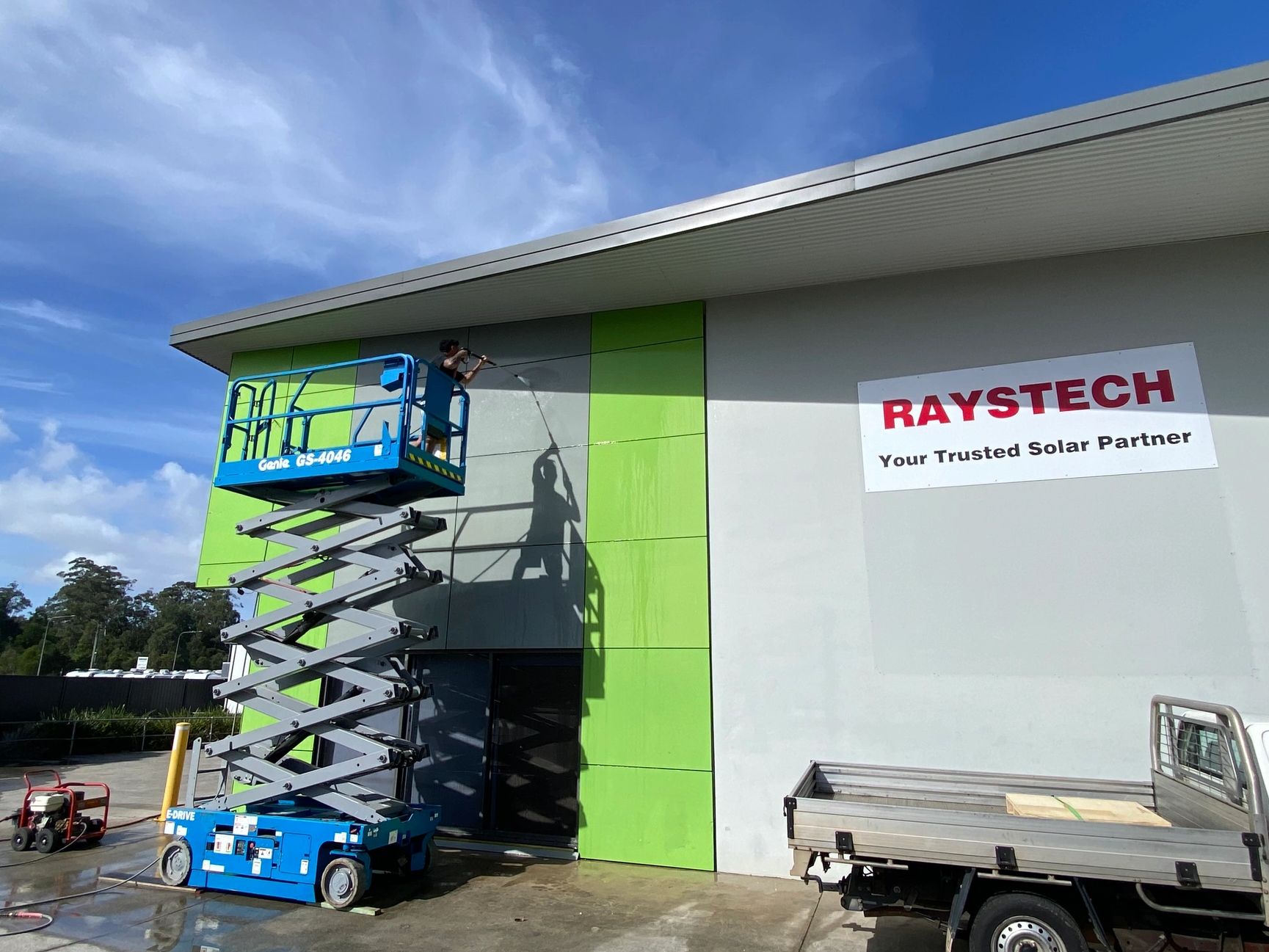 Coast Pro soft washing a commercial building from a scissor lift on the Sunshine Coast