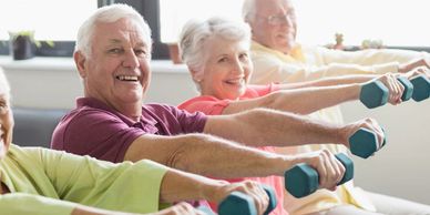 Seniors exercising with dumbbells, smiling and active.
