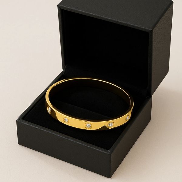 Elegant gold bracelet with diamonds in a black jewelry box.