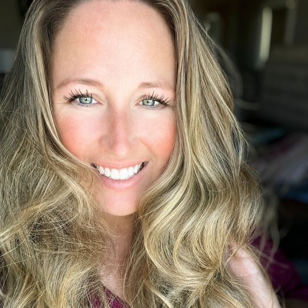 Smiling woman with long blonde hair and bright eyes.