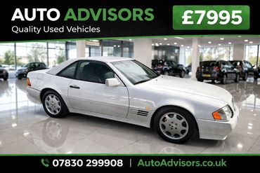 White vintage Mercedes-Benz coupe priced at £7995 in a showroom.