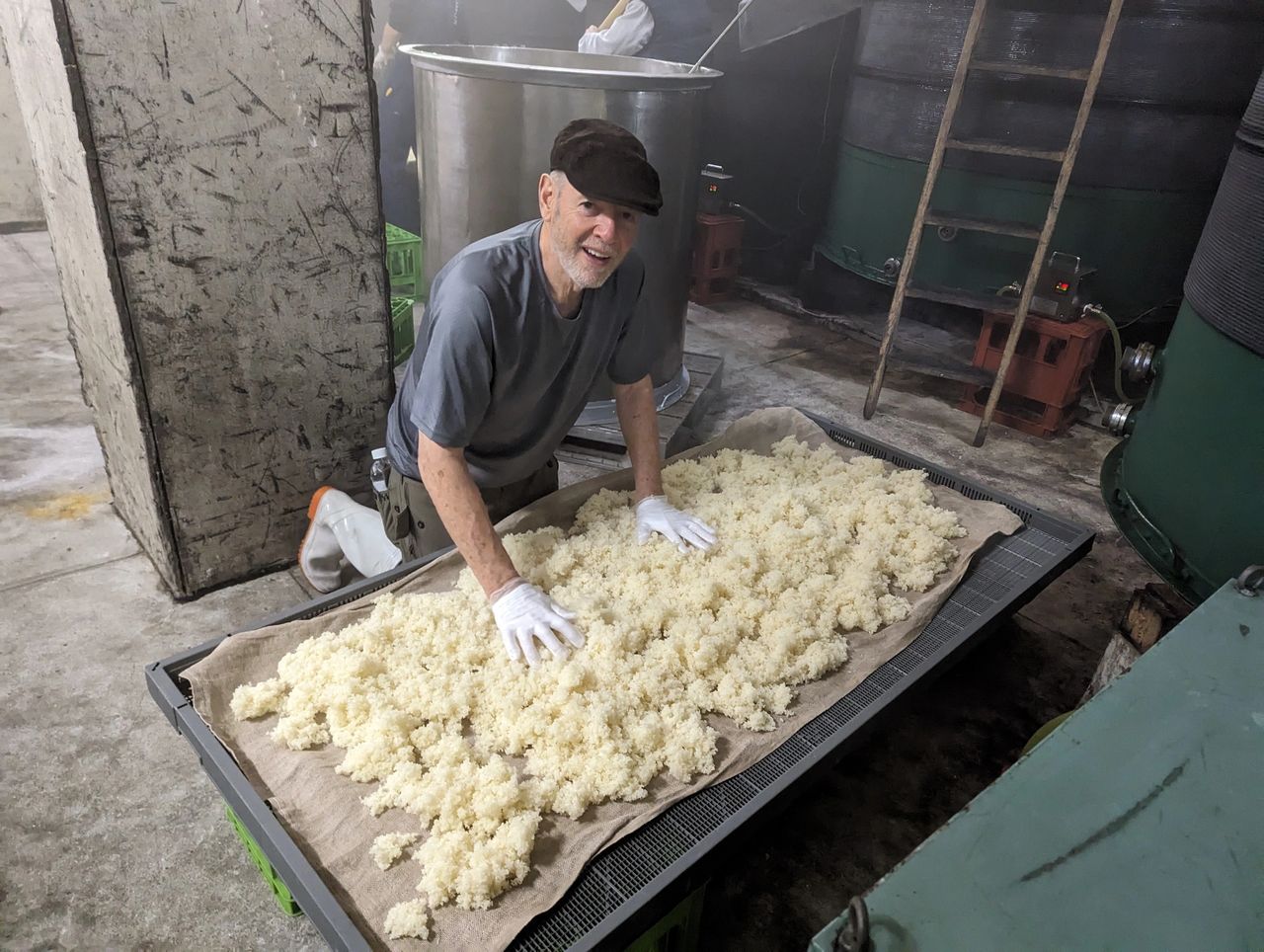 me, John Hornick, spreading rice on a canvas sheet to cool it for making Japanese sake