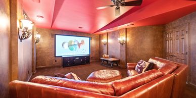Cozy home theater with leather sectional and projector screen.