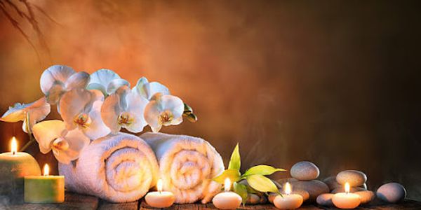 Spa items including towels, candles kept on a wooden table.