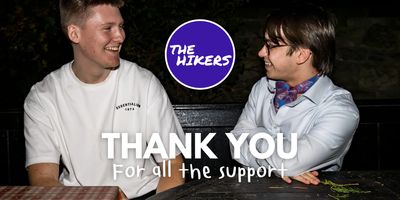 Two men smiling at each other with a thank you message and The Hikers logo.