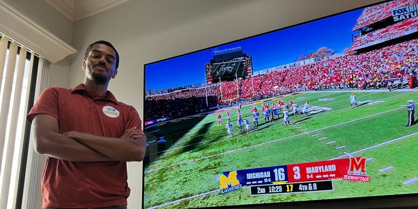 Man standing beside a mounted TV