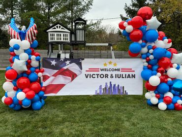 Corporate event balloon display in American flag colors featuring company banner.