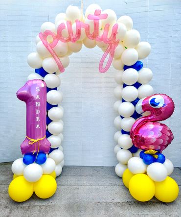 Kids birthday balloon arch with number one and flamingo balloons.