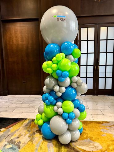 Organic balloon column featuring a 36" balloon topper adorned with RSM company logo.