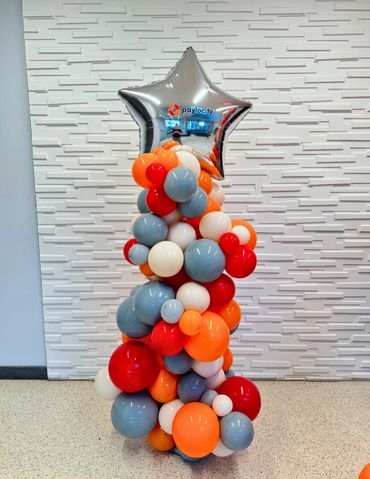 One organic balloon column with large silver star balloon topper and company logo.
