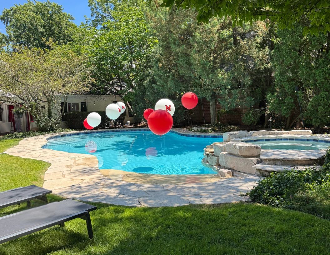 Jumbo helium balloons with university logo floating above the pool.