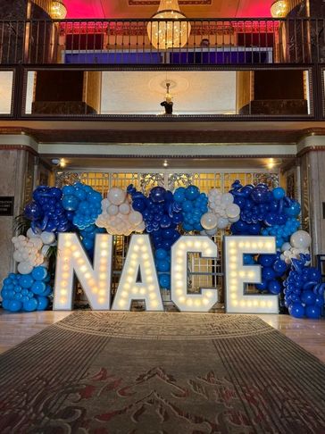 Marquee light-up letters surrounded by a colorful balloon garland