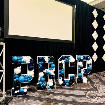 Custom balloon mosaic letters PRCP filled with balloons in colors dark blue, light blue, and white.