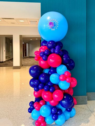 Organic balloon column with jumbo balloon topper and custom vinyl sign display.