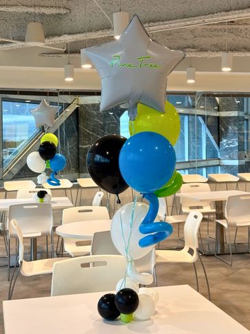 Helium swirl balloon centerpiece with star topper and custom brand logo.