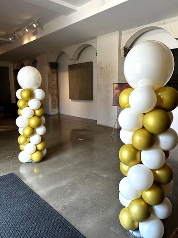 Two classic structured balloon columns in retro white and gold with large 36" balloon latex toppers.
