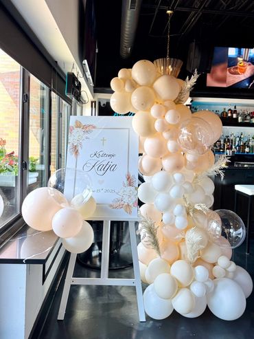 White easel sign with a balloon garland