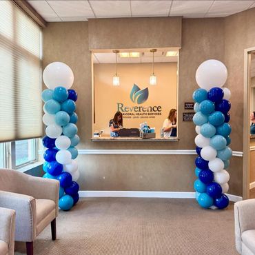 Two balloon columns displayed at a reception desk with women working behind the counter.