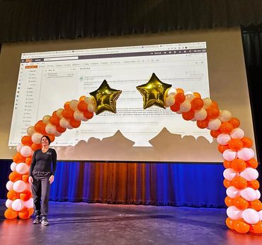 Split balloon arch topped with a large foils stars, designed for a vibrant school event celebration.