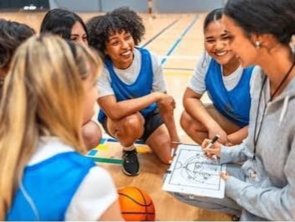Basketball team discussing strategy with coach.