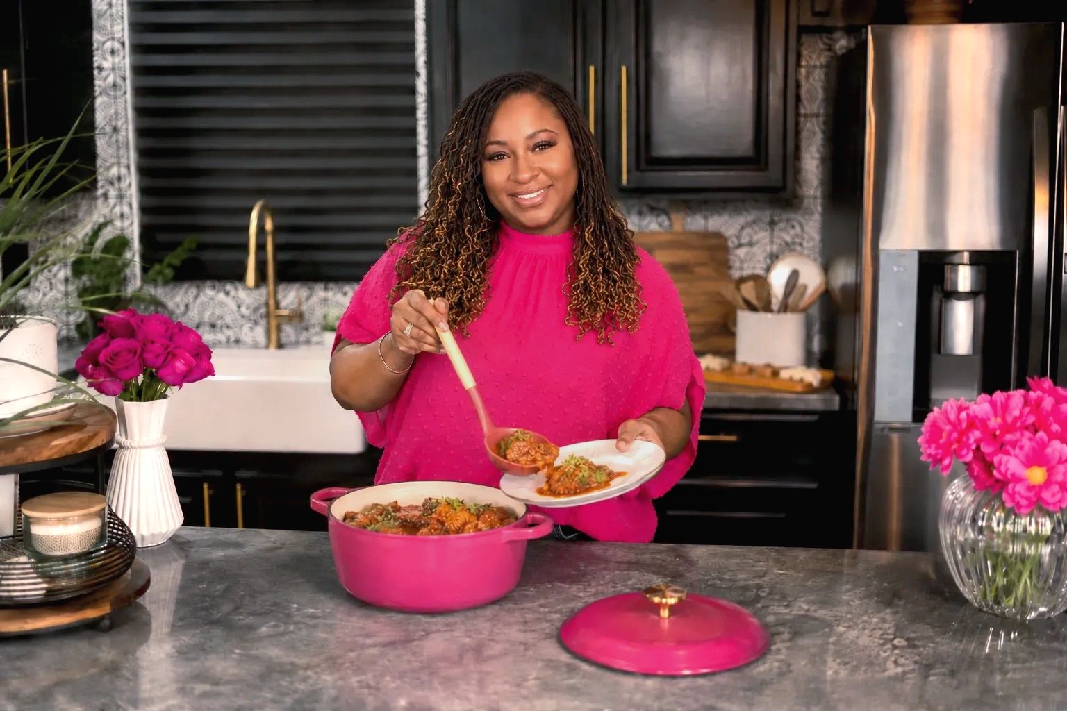 SistaLuvsToEat serves a homemade meal from a pink Dutch oven in a kitchen with pink flowers decor