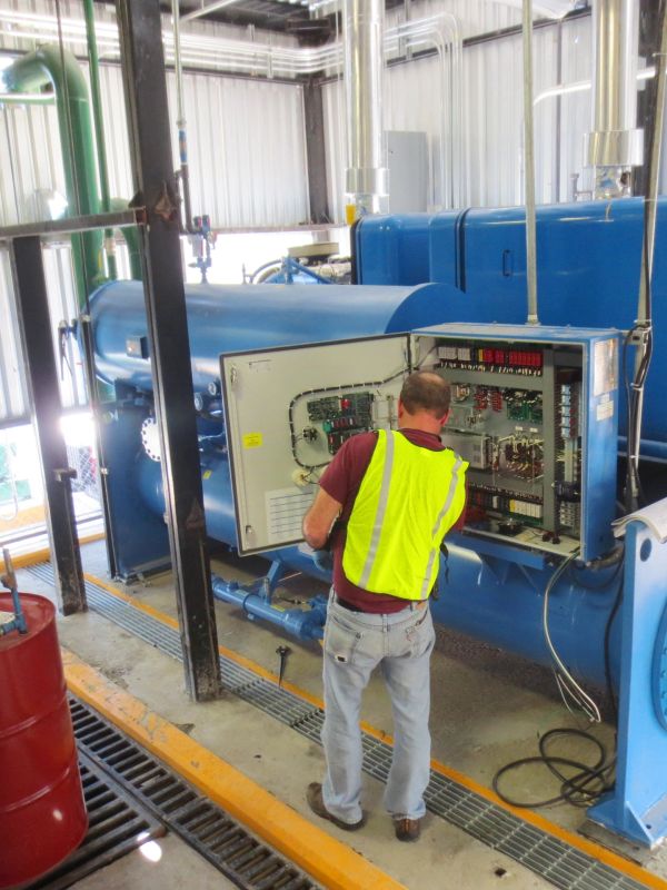 Técnico revisando equipo industrial en planta.