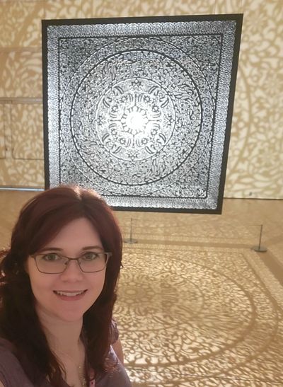 Julie in front of an art exhibit.