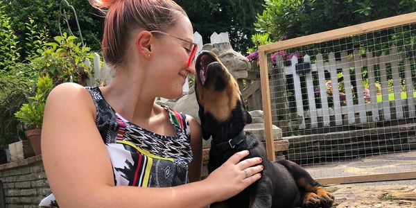 owner and her rottweiler puppy on a patio