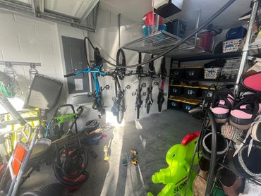 A well-organized garage with hanging bikes, tools, and storage bins.